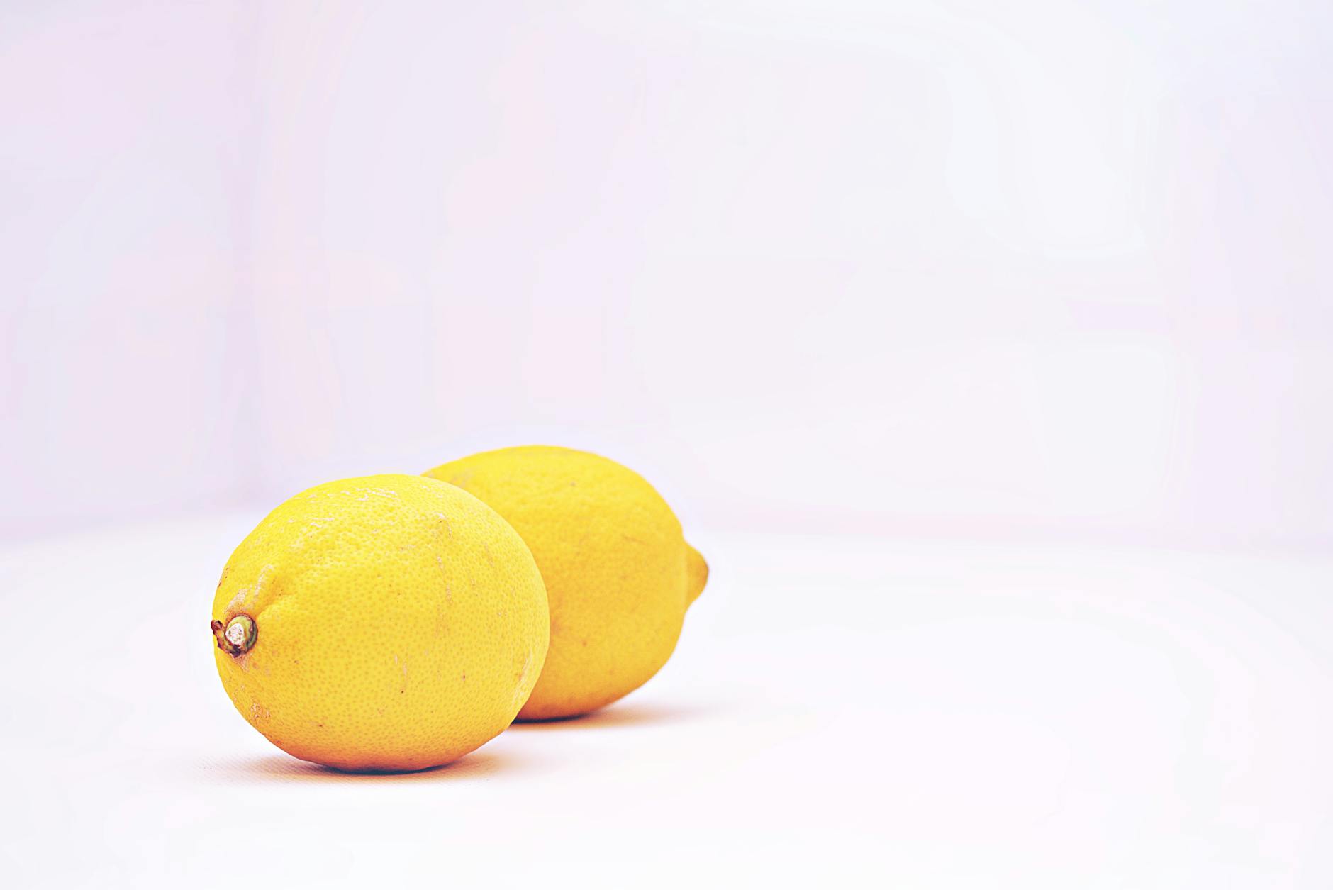 Hand holding an orange vibrator against purple backdrop, representing modern sensuality and intimate self-discovery