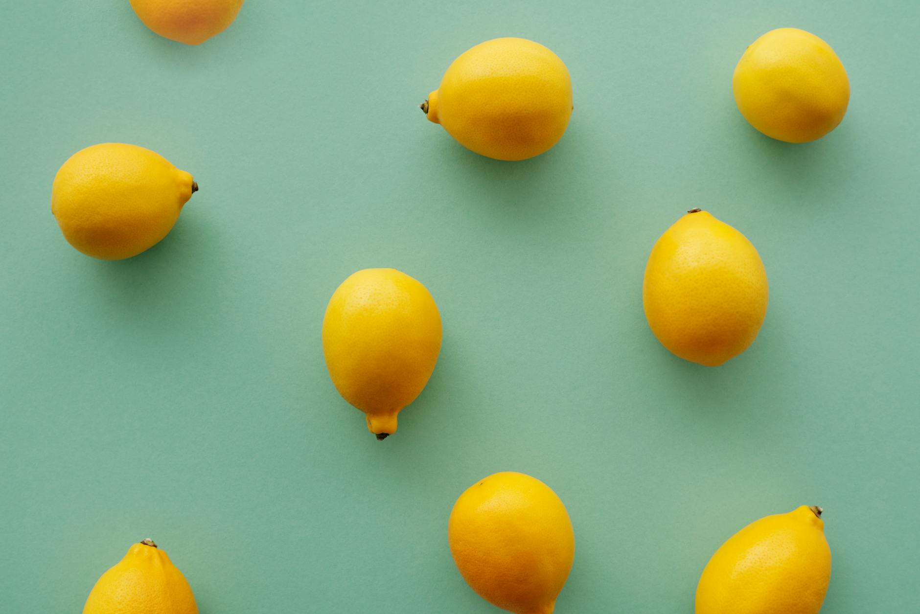 Hand holding a fresh lemon against a bright yellow background, symbolizing renewed vitality and sensory awakening