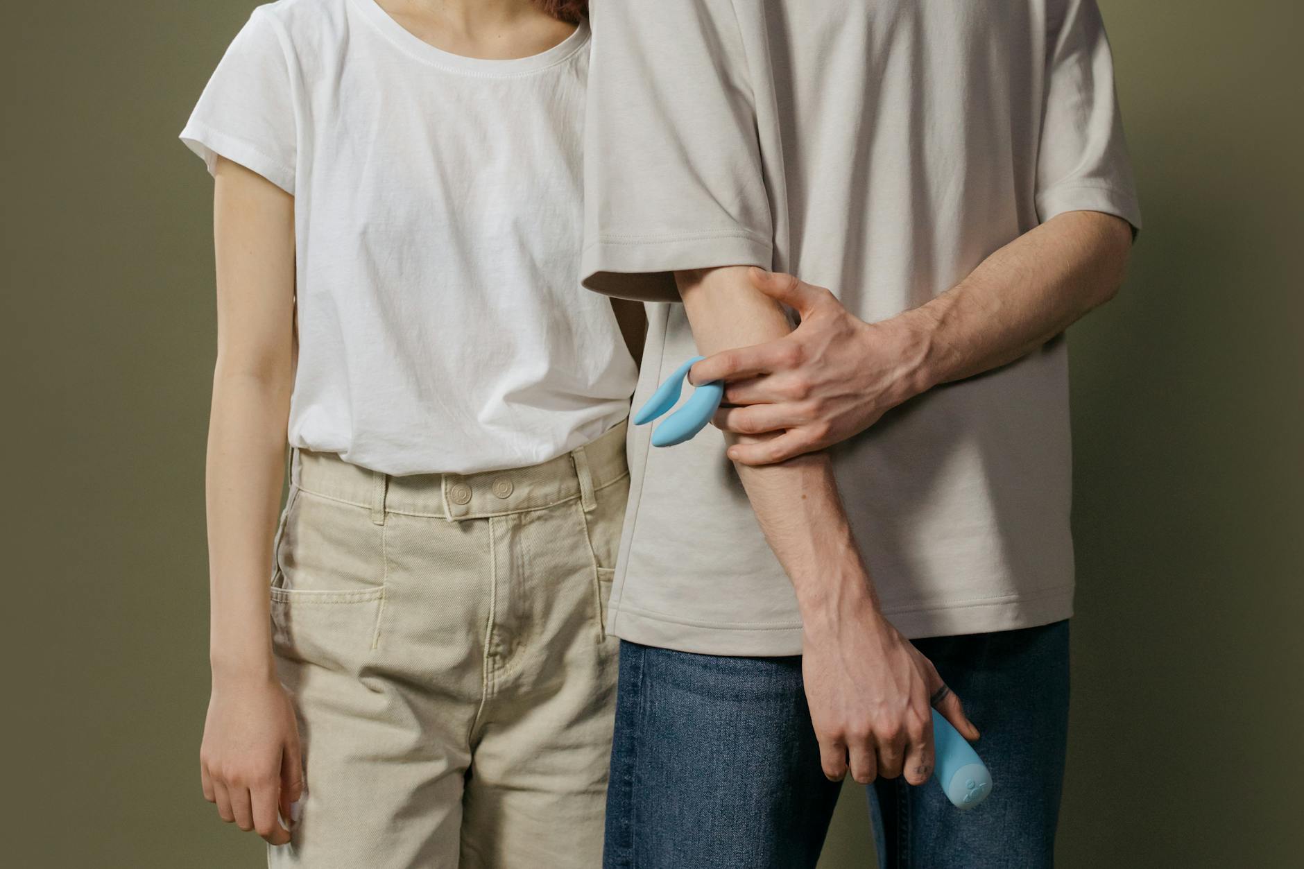 A couple reconnecting with intimacy, holding a blue vibrator together during relationship recovery.