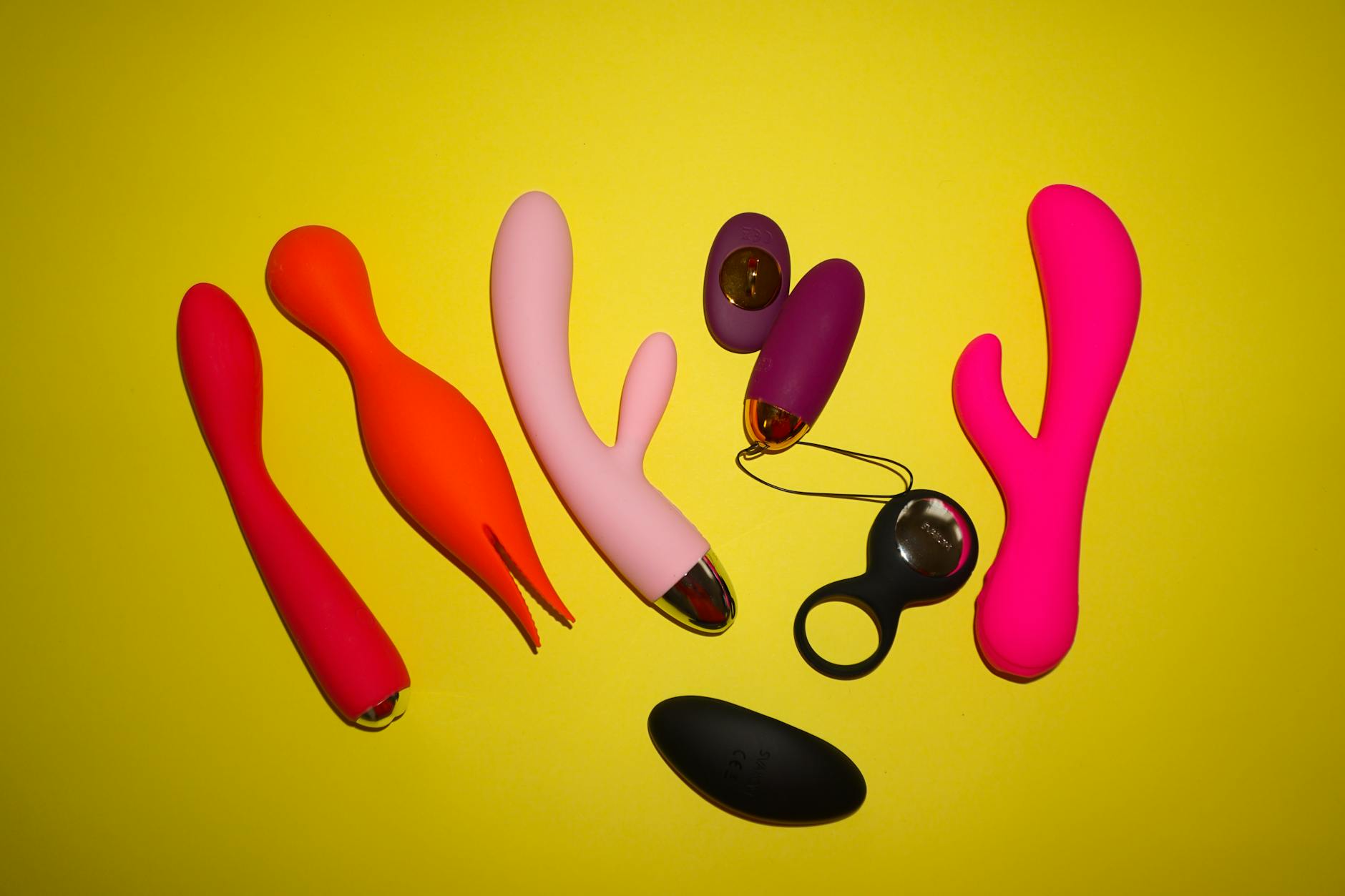 Vibrant collection of lemon clitoral vibrators and colorful adult toys on a bright yellow background